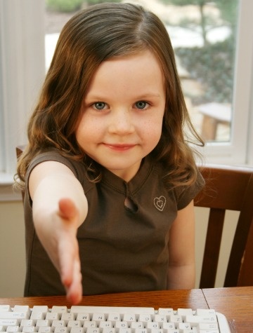 A young girl offers a handshake (focus on face)