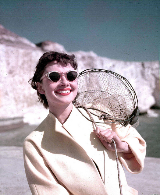 1951. A portrait of US Film star Audrey Hepburn pictured on the beach whilst carrying a net.